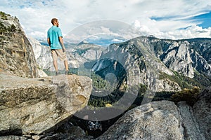 Traveler man in Yosemite National Park, scenic view at Valley and Mountains from Upper Yosemite Falls, California, USA