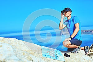 Traveler with map and Spyglass on the cliff