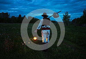 Traveler in old clothes with a knapsack and a kerosene lamp