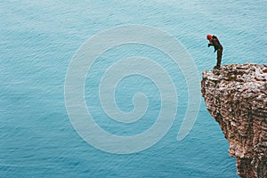 Traveler photographer on cliff above sea Travel Lifestyle concept adventure