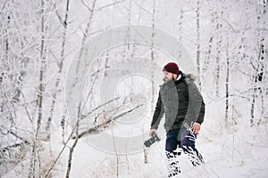 Traveler photographer taking pictures in the winter forest