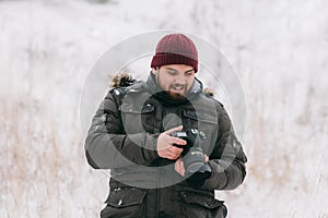 Traveler photographer taking pictures in the winter forest