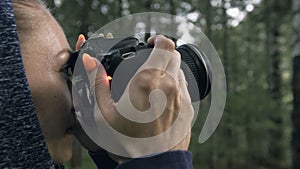 Traveler photographing scenic view in forest. One caucasian woman shooting close up look. Girl take photo video on dslr