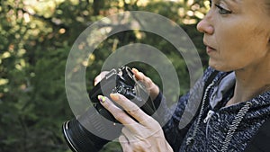 Traveler photographing scenic view in forest. One caucasian woman shooting close up look. Girl take photo video on dslr