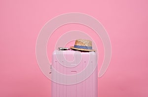 Traveler pink suitcase and passport document over pink background, Journey and travel.