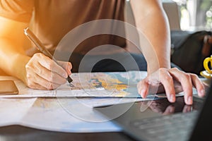 Traveler is planning vacation using the world map. Man is writing notes and pointing on the map while the man is discussing