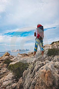 Traveler with a portable solar battery attached to his backpack