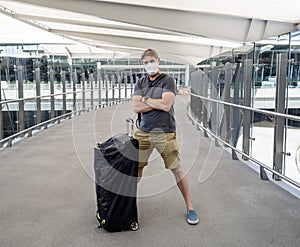 Traveler with protective face mask at airport terminal worried of quarantine. COVID-19 and travel