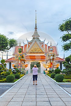 Traveler selfie and take a photo two statue giant at churches Wat Arun, Bangkok, Thailand