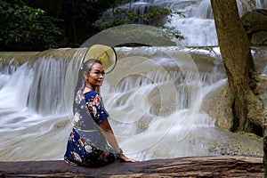 Traveler sit relax on timber at Erawan Waterfall and  natural