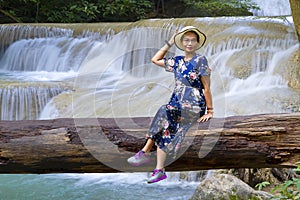 Traveler sit on timber at Erawan Waterfall and  natura