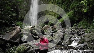 A traveler sits relaxing and sipping hot coffee on a large rock river