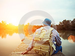 Traveler sitting on the lake on the wooden bridge