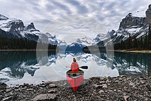 Traveler sitting with paddle on canoe in Maligne lake at Spirit Island