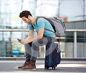 Traveler sitting sending text message