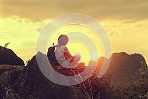 traveler sitting on top mountain with looking sunset