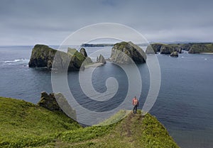 Traveler Standing on a Cliff and Looking on Beautiful Unnamed Bay, Shikotan Island, Coastline of Pacific Ocean, Russia.