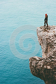 Traveler standing on cliff over cold sea alone Travel Lifestyle concept outdoor