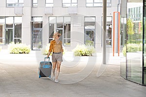 Traveler suitcase, woman carrying a suitcase in a travel location on holidays trip with lens flare technique, traveling
