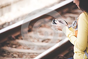 Traveler and tourist asian young women wearing backpack holding map and camera, waiting for a train.