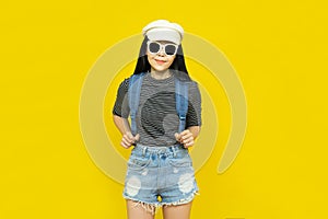 Traveler tourist beautiful young asian woman in casual clothes and sunglasses with Backpack isolated on yellow background.Summer