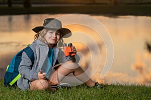 Traveler tourist kid. Scout boy wearing explorer hat and backpack outdoor. Explorer and adventure with binocular.