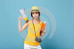 Traveler tourist woman in yellow casual clothes hat hold tickets megaphone camera isolated on blue background. Female