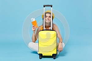 Traveler tourist woman in yellow summer casual clothes hat hold tickets luggage isolated on blue background. Female