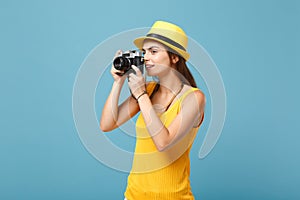 Traveler tourist woman in yellow summer casual clothes, hat with photo camera  on blue background. Female