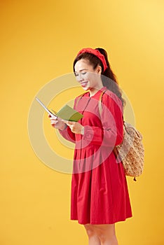 Traveler tourist young beautiful asian woman with backpack, smiling and standing on yellow background. Summer holidays, vacation