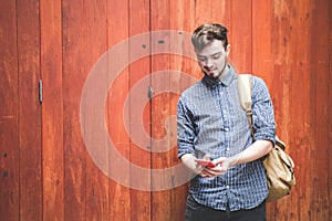 Traveler and tourist  young man wearing backpack using smartphone. Travel backpack concept