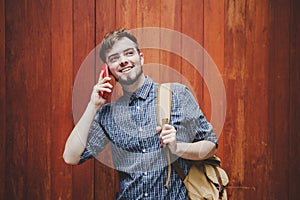 Traveler and tourist  young man wearing backpack using smartphone. Travel backpack concept