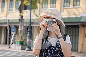 Traveler, travel asian young woman or girl use camera take photo, old town street, city tourism on happy sunny day. Backpacker