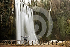 Traveler under waterfall