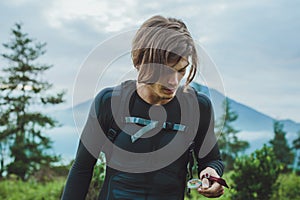 Traveler using a compass to get Batur volcano and Agung mountain