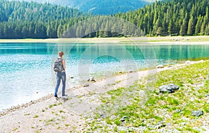 Traveler is walking on the lake coast