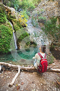 Traveler, woman admires waterfall