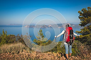 Traveler woman with backpack stands on the cliff