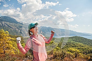 Traveler woman with braces enjoy and fun with hands up against amazing nature landscape