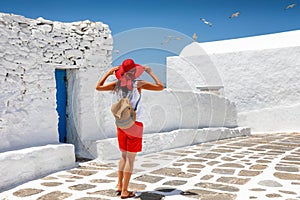 Traveler woman enjoys the classic Greek Cycladic architecture on Mykonos, island Greece