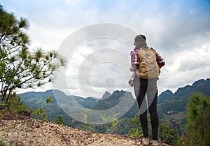 Traveler woman feeling victorious facing on the mountain,