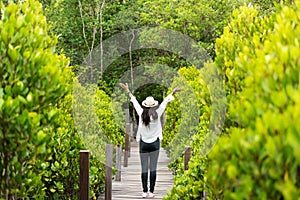 Traveler woman happy feeling freedom good and relax on the bridge wood in travel study nature forest