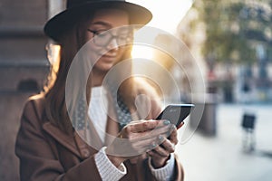 Traveler woman holding in hands mobile phone. Close up technology smartphone online connect. Girl tourist in glasses using gadget