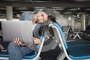 Traveler woman with laptop at airport.Young smiling Asian girl