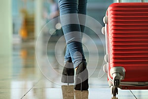 Traveler woman legs walking carrying a suitcase