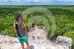 Traveler woman looks the Nohoch Mul pyramid in Coba, Yucatan, Mexico