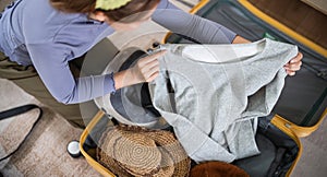 Traveler woman packing prepare stuff and outfit clothes in suitcases travel bag luggage for holiday at home, weekend