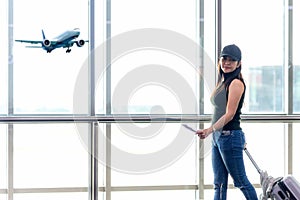 Traveler woman plan and backpack see airplane flight at the airport glass window,