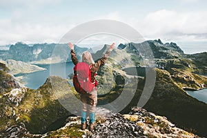 Traveler woman raised hands discovering mountains of Norway