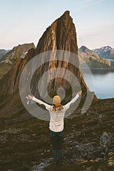 Traveler woman raised hands enjoying mountain view traveling in Norway alone summer vacations healthy lifestyle outdoor